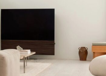 CANVAS L soundbar mounted on the wall with a TV on top, in a minimalist living room