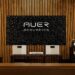 Pair of Auer Acoustics Versura V6 loudspeakers in a wood-paneled listening room