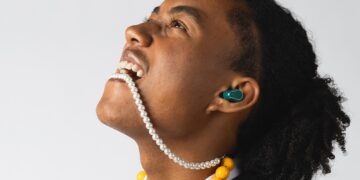 Fresh 'n Rebel Twins Elite 2 true wireless earbud worn in-ear during a colourful lifestyle shoot