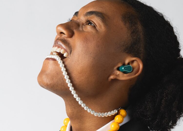 Fresh 'n Rebel Twins Elite 2 true wireless earbud worn in-ear during a colourful lifestyle shoot