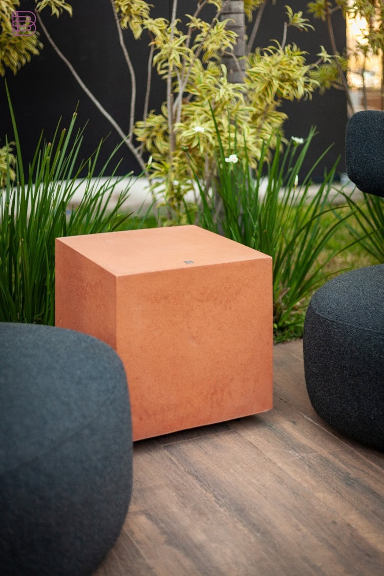 Magna Audio Brutalist Pathway concrete subwoofer in terracotta finish on an outdoor patio