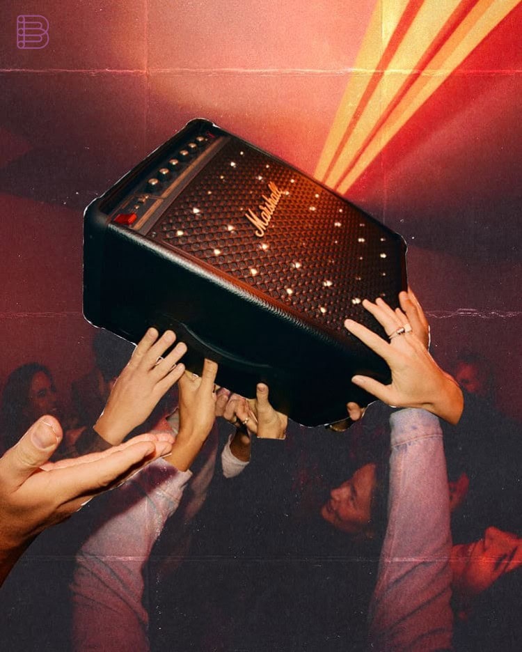 Marshall Bromley 450 speaker held up by hands at a party with light show