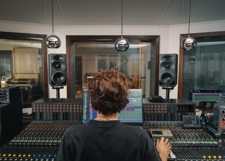 Neumann KH 310 II studio monitors flanking a mixing console in a professional control room