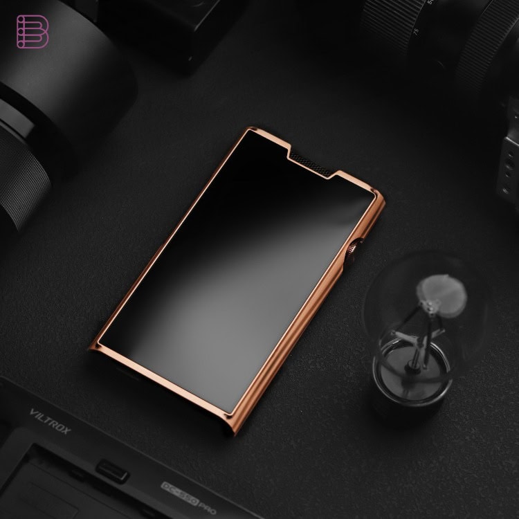 Shanling M8T Cu copper flagship DAP resting on a desk beside camera gear