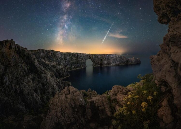 Sony SEL814G fisheye lens sample photo of a starlit sea cliff arch