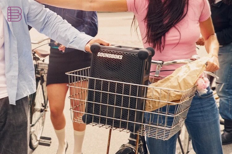 Soundboks Rider portable speaker carried in a bicycle basket