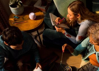 The new HomePod mini 2 glowing on a side table in a living room