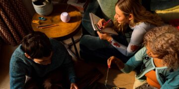 The new HomePod mini 2 glowing on a side table in a living room