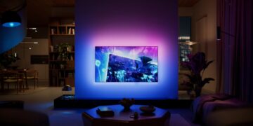 Philips OLED+951 Ambilight TV glowing in a darkened living room