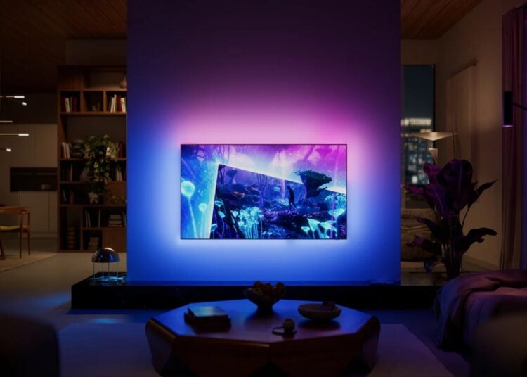 Philips OLED+951 Ambilight TV glowing in a darkened living room