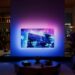 Philips OLED+951 Ambilight TV glowing in a darkened living room