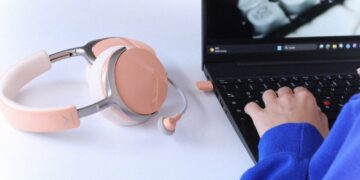beyerdynamic AVENTHO Y with detachable microphone next to a laptop with the low-latency dongle