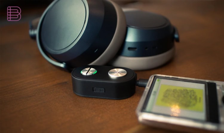 iFi UP Travel Max on a wooden table with headphones