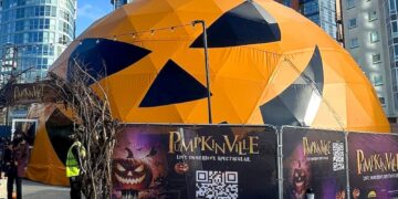 Orange jack-o-lantern-shaped geodesic dome exterior at Gunwharf Quays, Panasonic and Holovis Pumpkinville installation