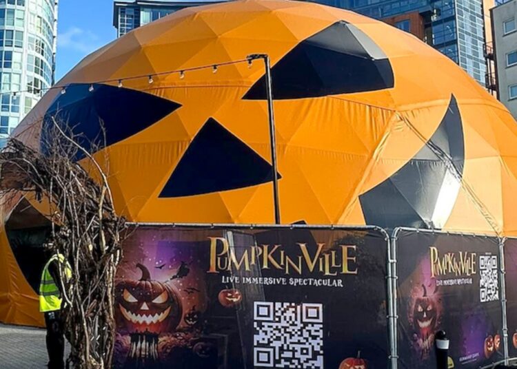 Orange jack-o-lantern-shaped geodesic dome exterior at Gunwharf Quays, Panasonic and Holovis Pumpkinville installation