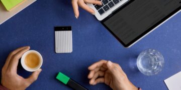 Plaud Note Pro AI voice recorder on a desk next to a laptop
