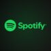 Spotify logo with green circle and sound waves beside the wordmark on a dark green-black gradient background