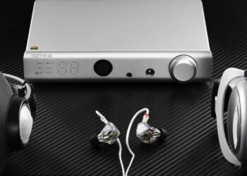Topping A90 Discrete headphone amplifier flanked by over-ear and in-ear headphones