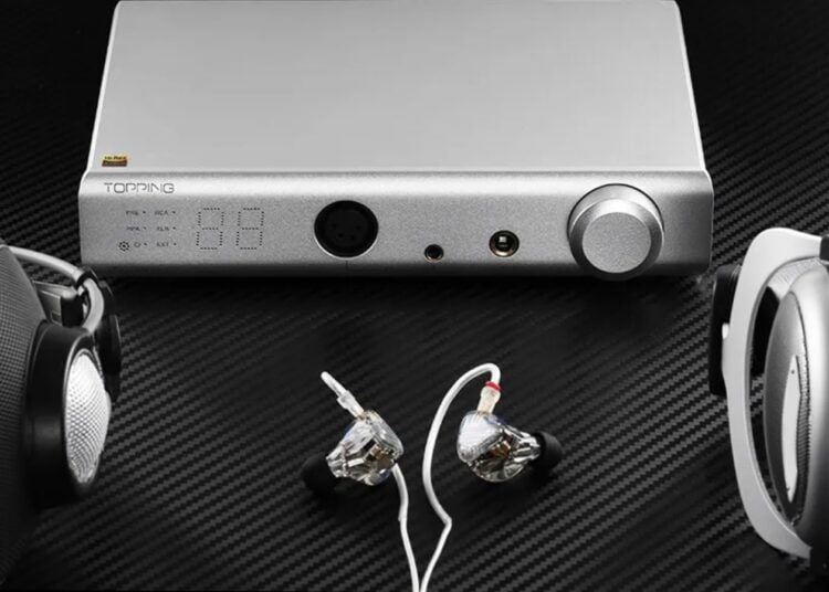 Topping A90 Discrete headphone amplifier flanked by over-ear and in-ear headphones