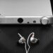 Topping A90 Discrete headphone amplifier flanked by over-ear and in-ear headphones