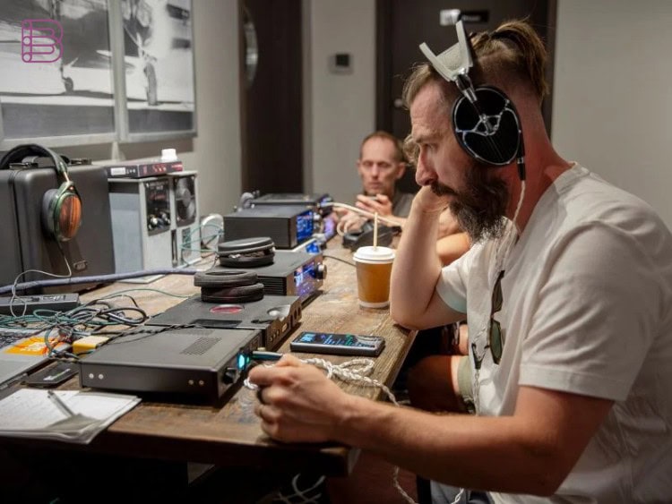 Visitor listening to headphones at a demo station during the Vancouver Headphone Festival